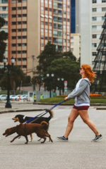 Moça passeando com cachorro.